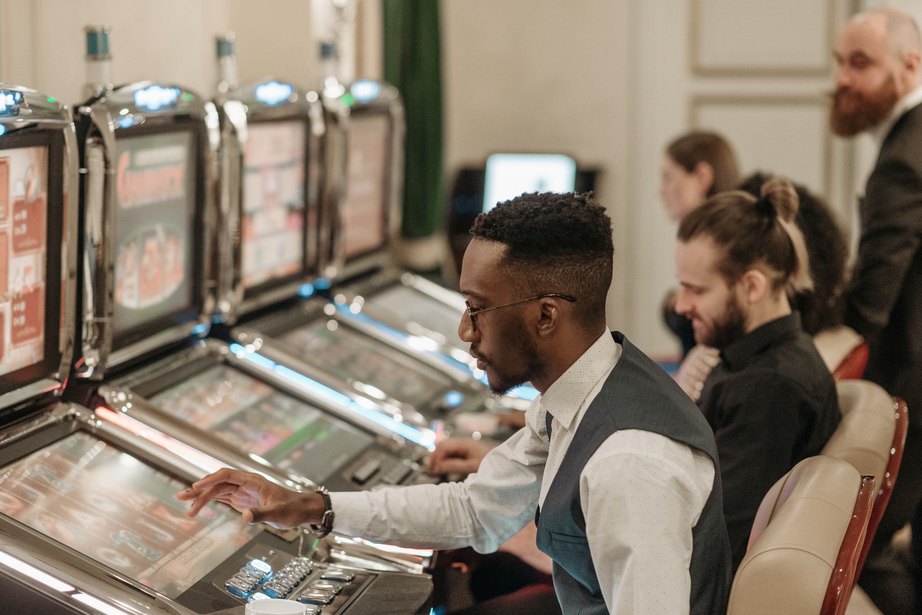 Due persone sedute alle macchine a rulli in una sala da gioco