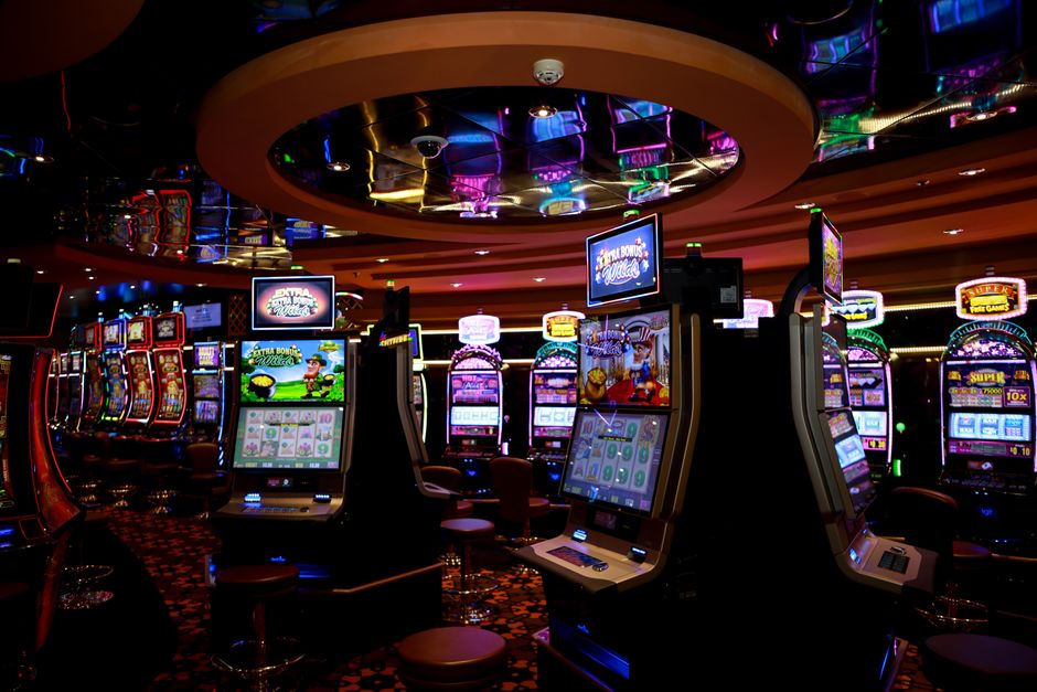 Fila di macchine a rulli illuminate in una sala da gioco