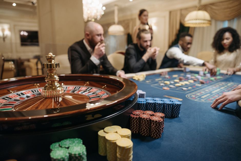 Giocatori intorno a un grande tavolo da gioco con gettoni e ruota
